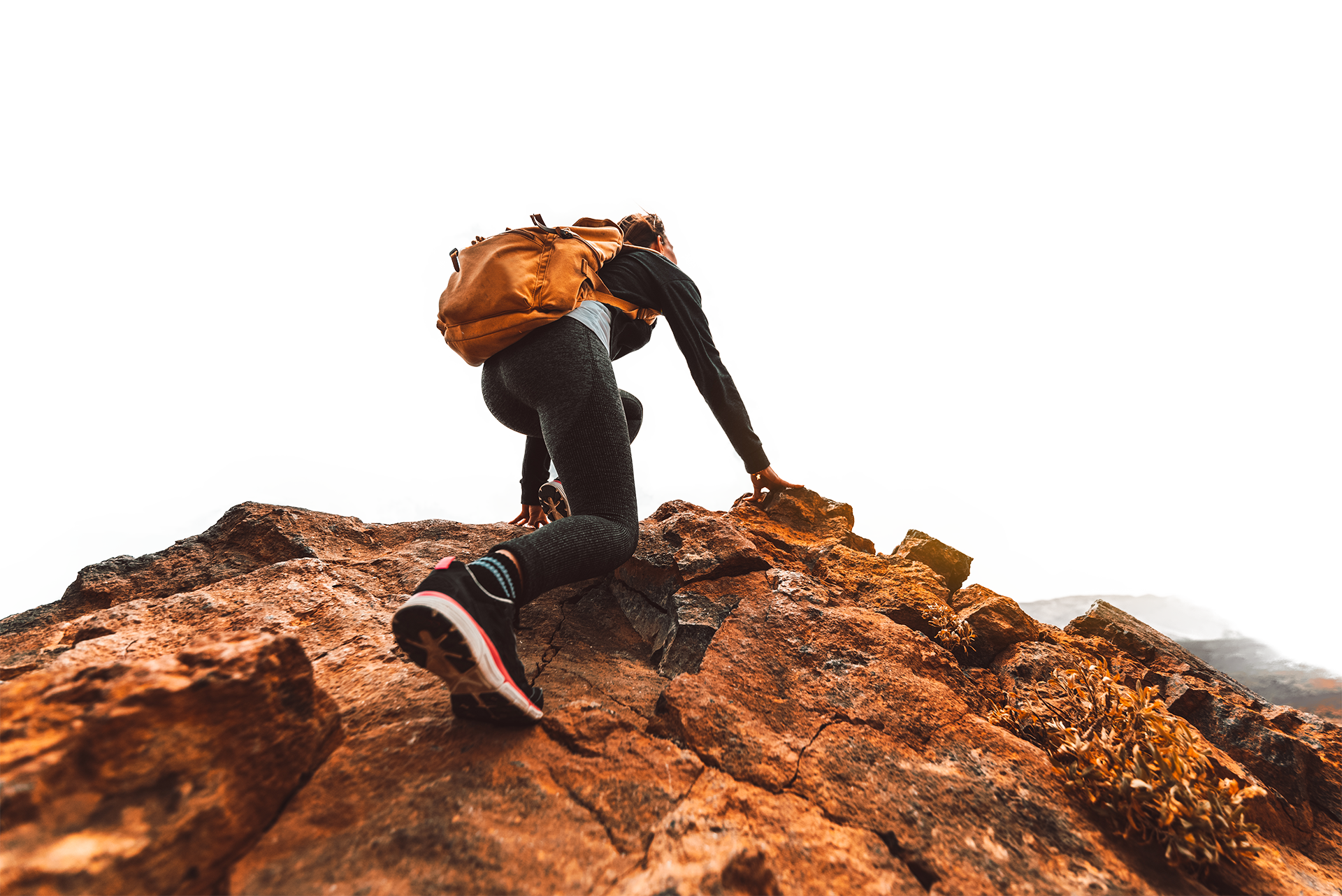 Mujer escalando hasta la cima de una montaña